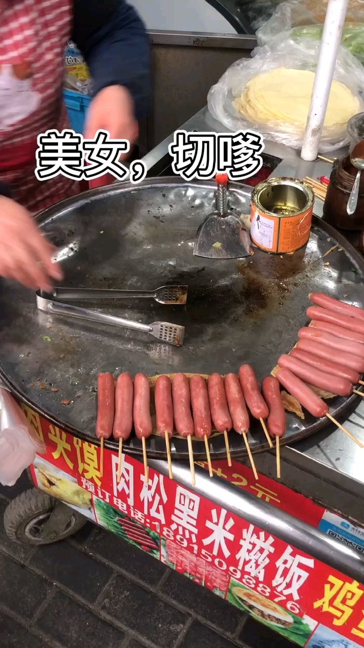 一到放学下班的时间就看到新村马路边的鸡蛋饼摊,摊位买鸡蛋饼吃的人很多一张软薄饼皮,两个鸡蛋