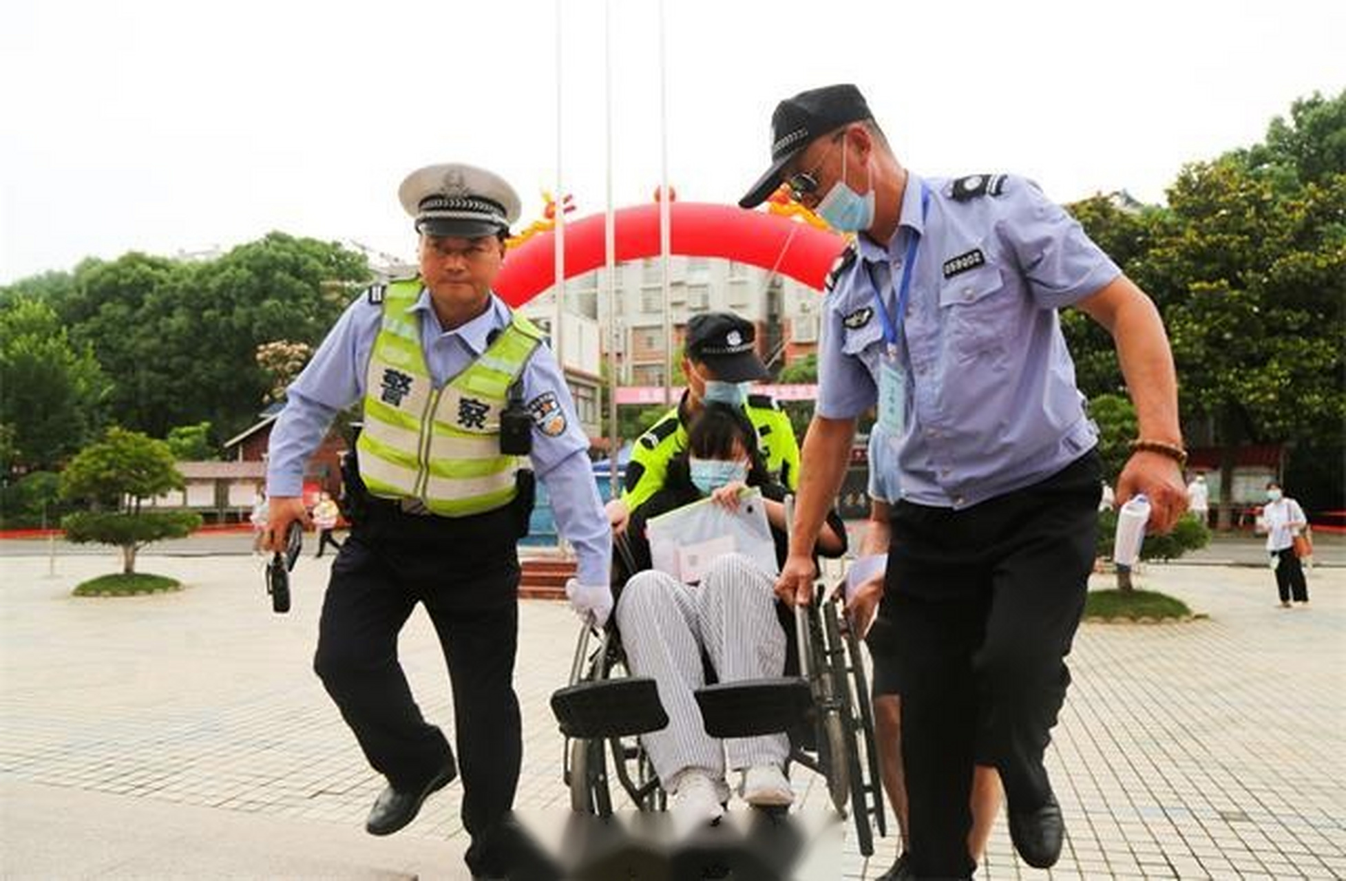 【庐江:考生坐轮椅参加中考 交警细心护送】6月14日,在庐江县第五中学