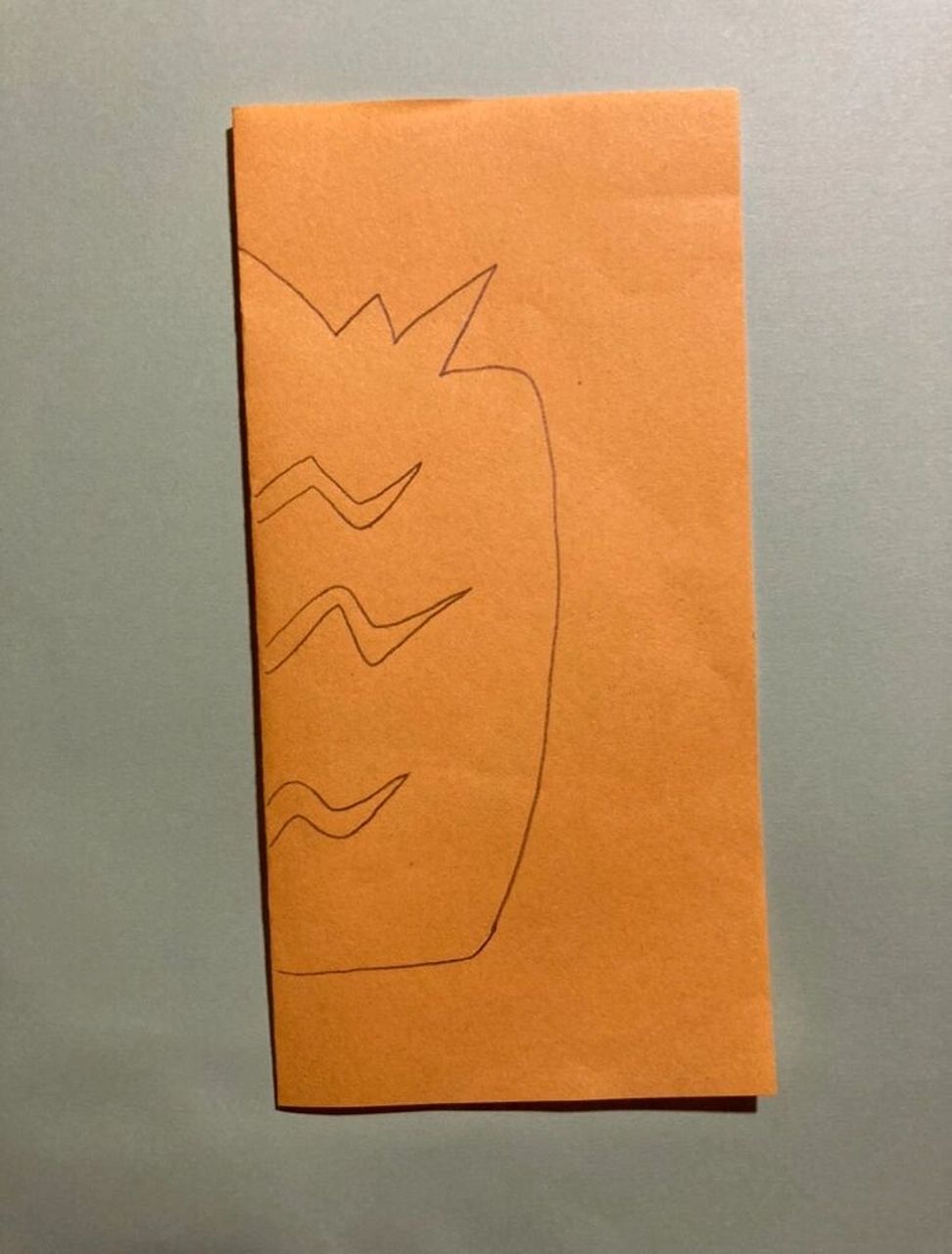 剪纸 筒单的菠萝剪纸,将正方形纸对折,画出线稿,用剪刀剪出形状即可