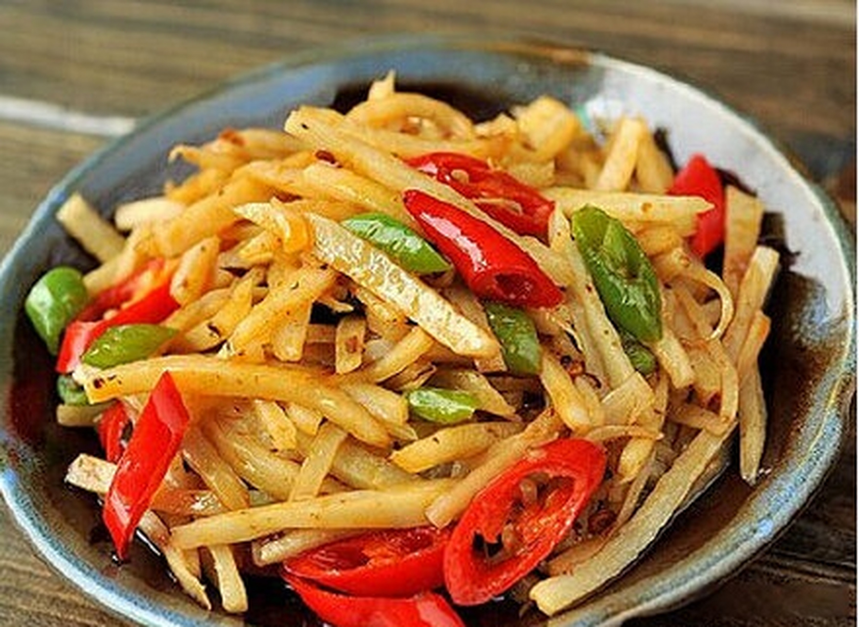 【豉椒辣炒藕丝】嫩藕洗净去皮,切成藕丝;青红椒洗净切成圈;锅烧热,放