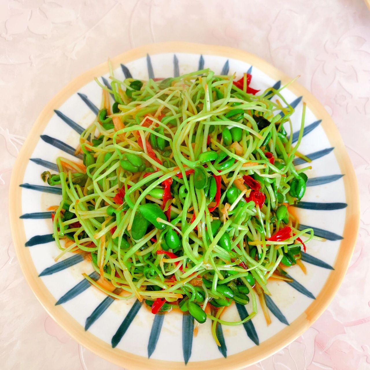 豆芽去根,锅中少许橄榄油,放入蒜末辣椒丝爆锅,放入豆芽爆炒,海鲜酱油