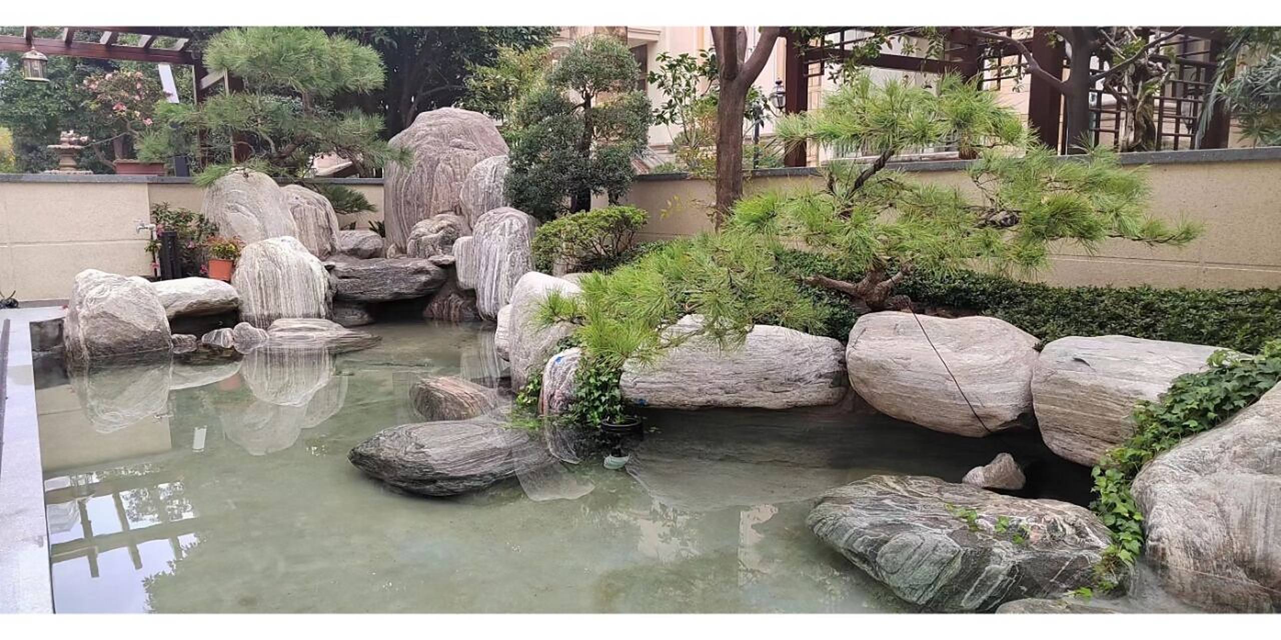 泰山石庭院假山鱼池案例分享 很多人喜欢用黑山石或是黄蜡石作为鱼池