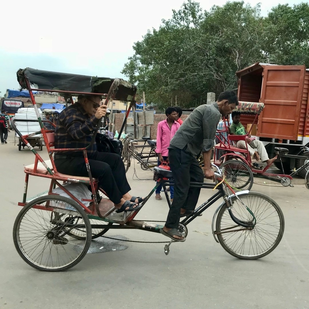 印度德里街头的人力三轮车夫,这个小伙子看起来很累的样子,一点都踩不