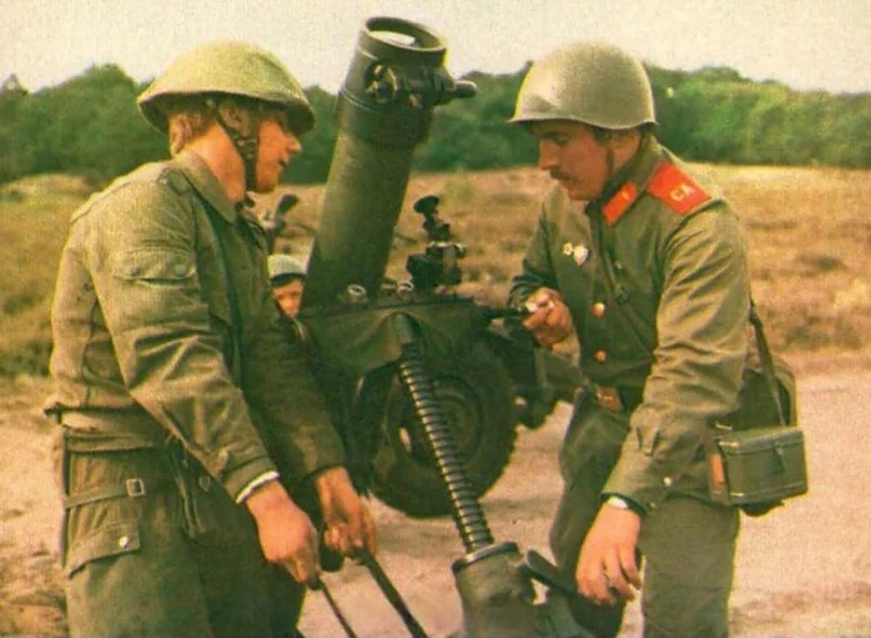 02#趣聊军事圈# 冷战时期,一名苏军士兵与一名东德士兵正在调整1门