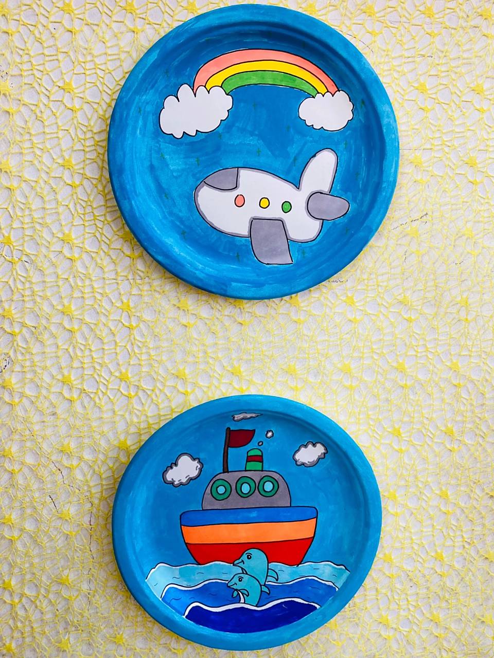 幼儿园盘子画 教室电视下面的墙还空着,贴上纹格布,再画了几个好看的