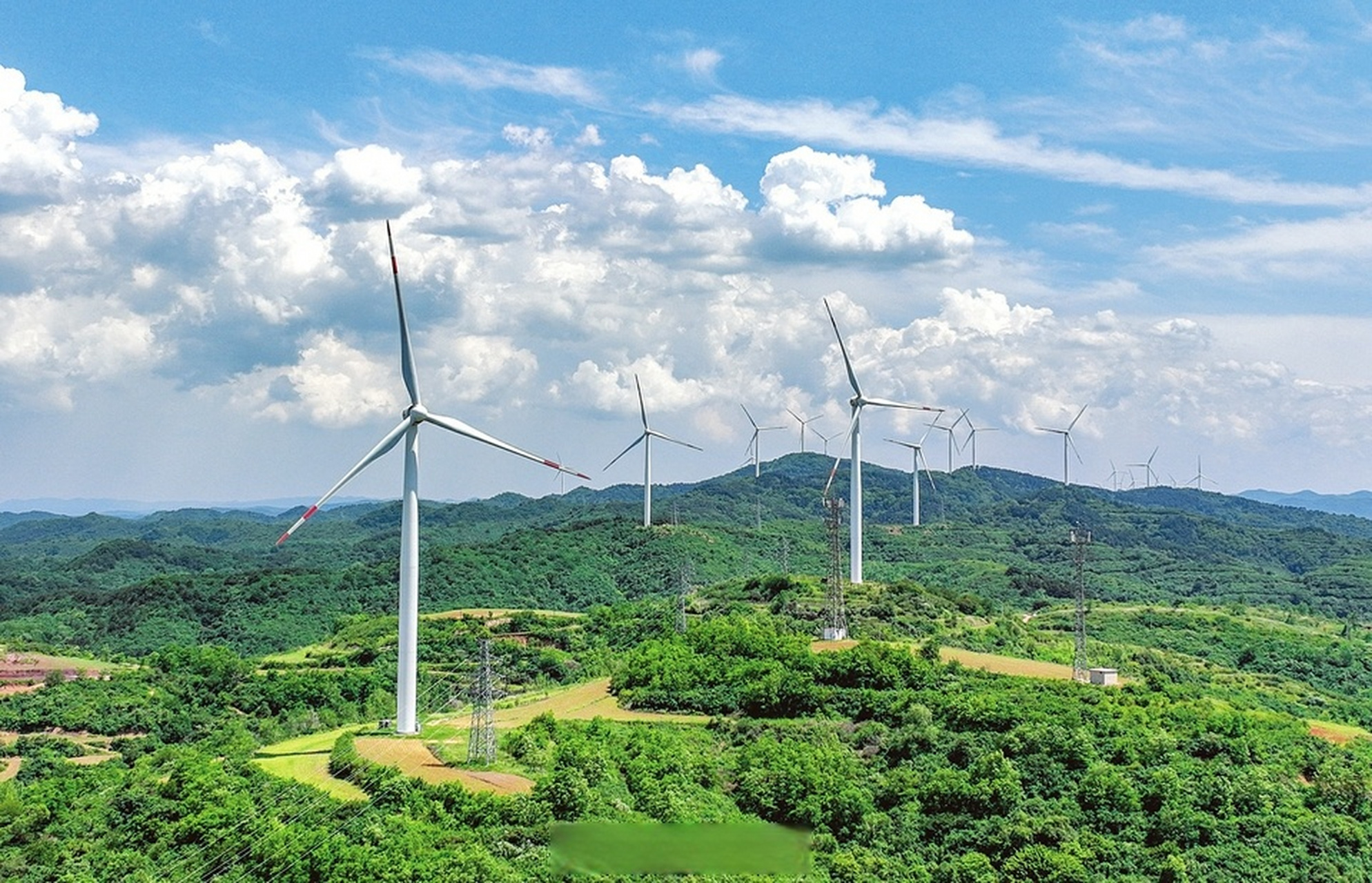 航拍镜头下的华润新能源浮山四十里岭风力发电机高耸挺立,在蓝天白云