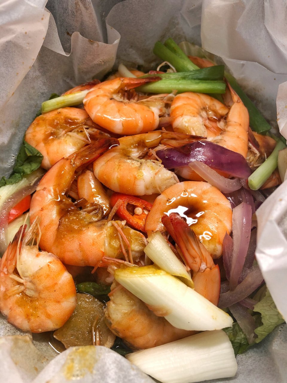 懒人菜系列 【纸包虾】硅油纸铺上生菜和爆香后的洋葱,蒜瓣;控干水分