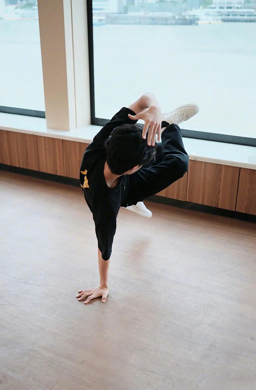 王一博身着热烈团服的地板动作定帧图,单手撑地,核心真强[思考]