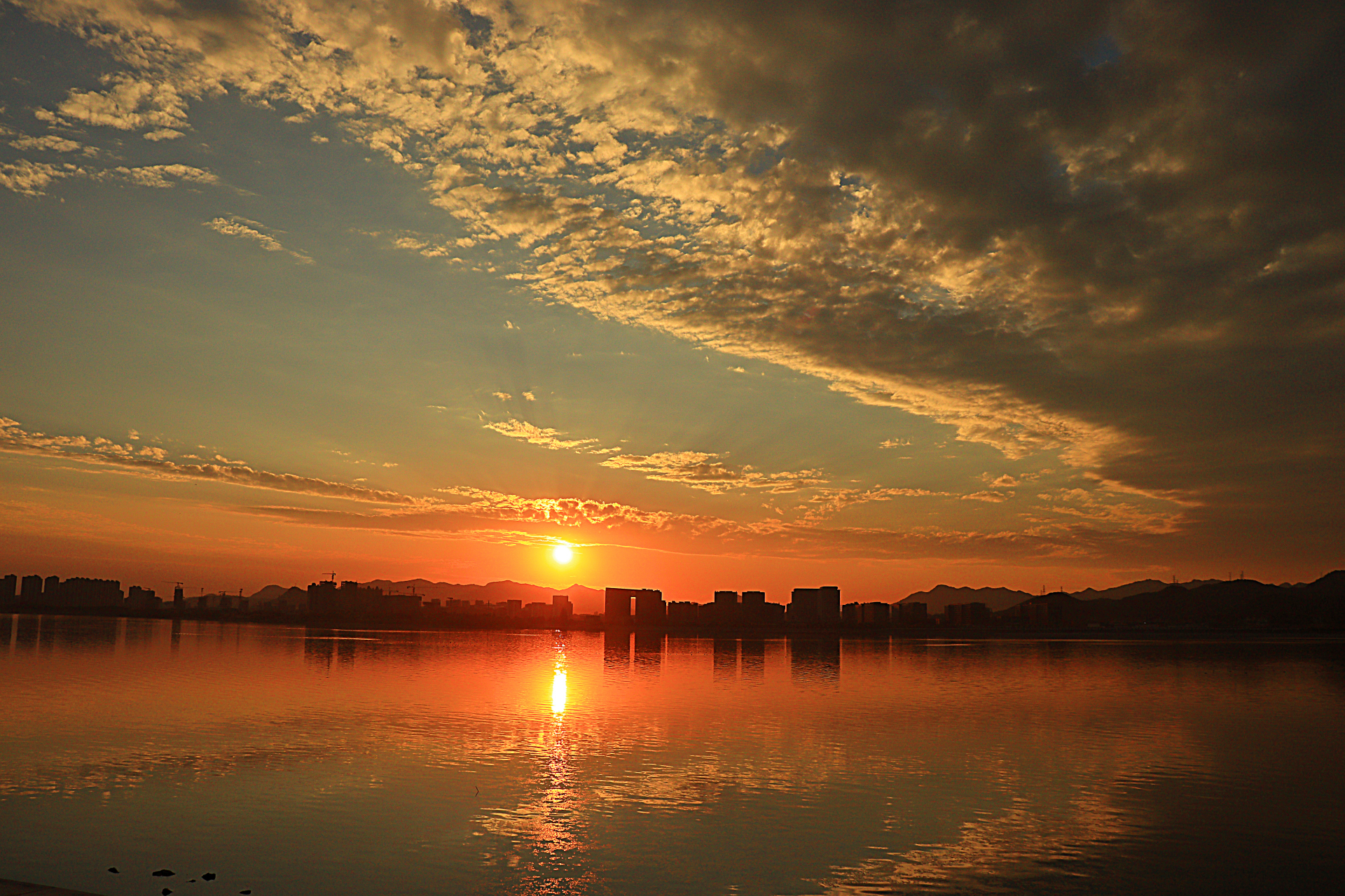 今天傍晚在柔和的阳光和漂亮的云彩下,湖面荡起涟漪,波光粼粼,倒影着