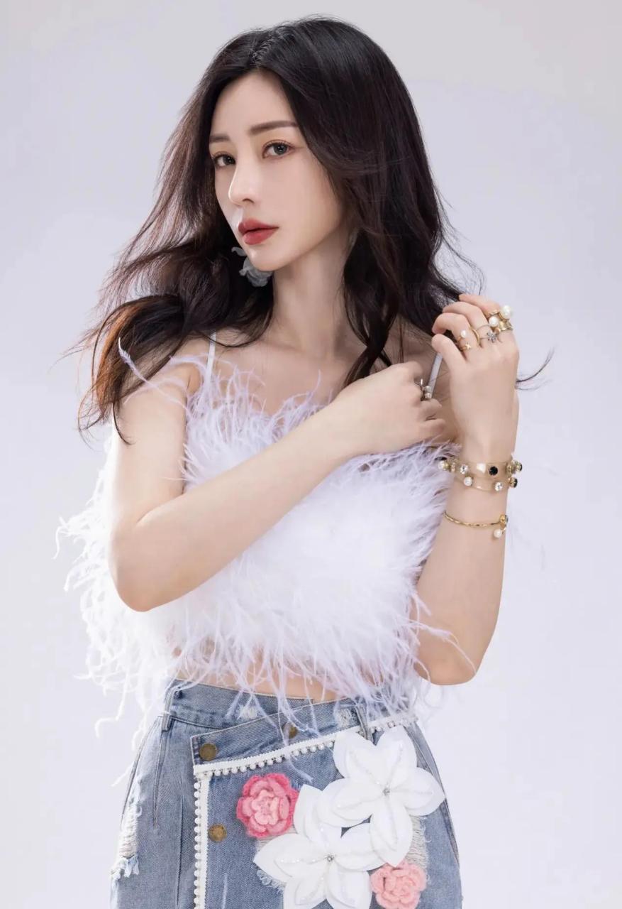 在这组时尚大片中,柳岩以纯白色绒毛吊带搭配针织百合花图案牛仔包臀