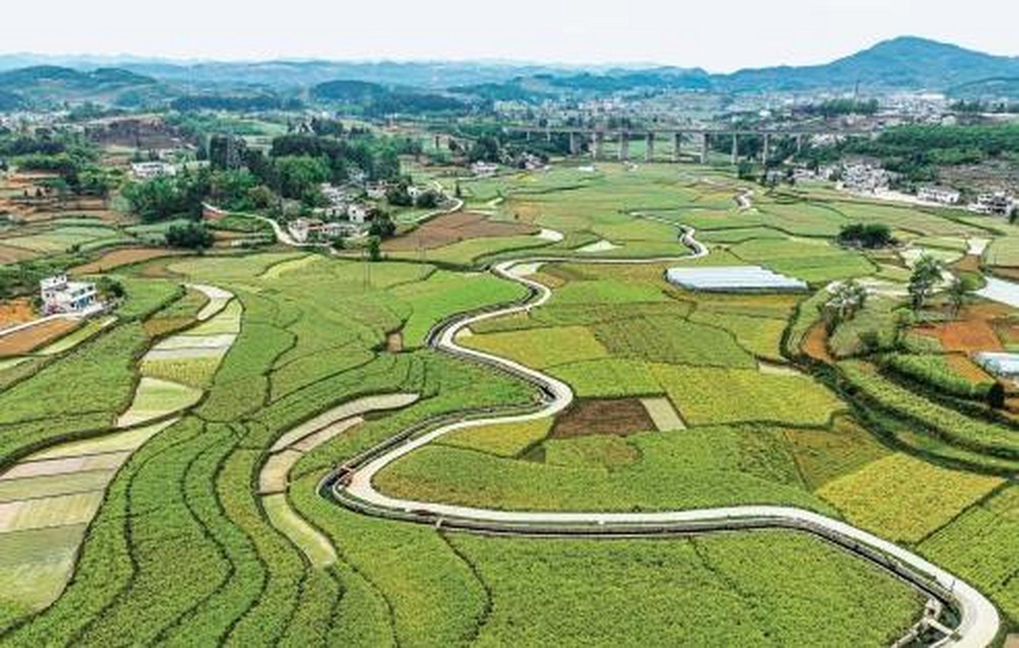 4月28日,在贵州省黔西市金碧镇铧口寨社区,油菜田与村庄,高速路相映成