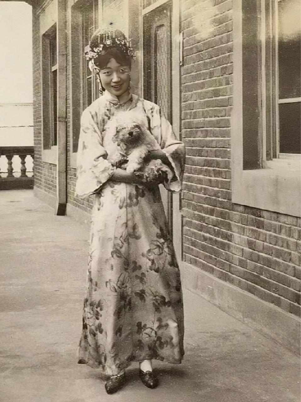 历史老照片,婉容 离开皇宫后的婉容,抱着宠物狗,很开心.