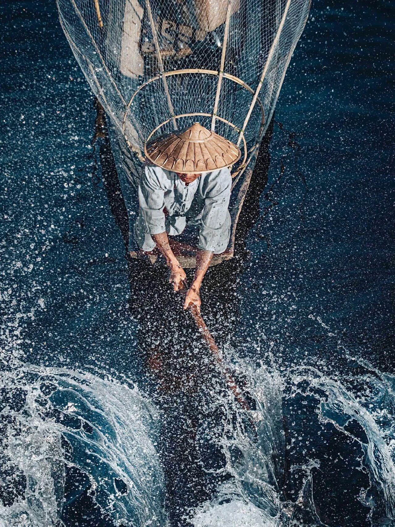 来自摄影师:jord hammond 这张照片是一个渔民在水中撒网的场景