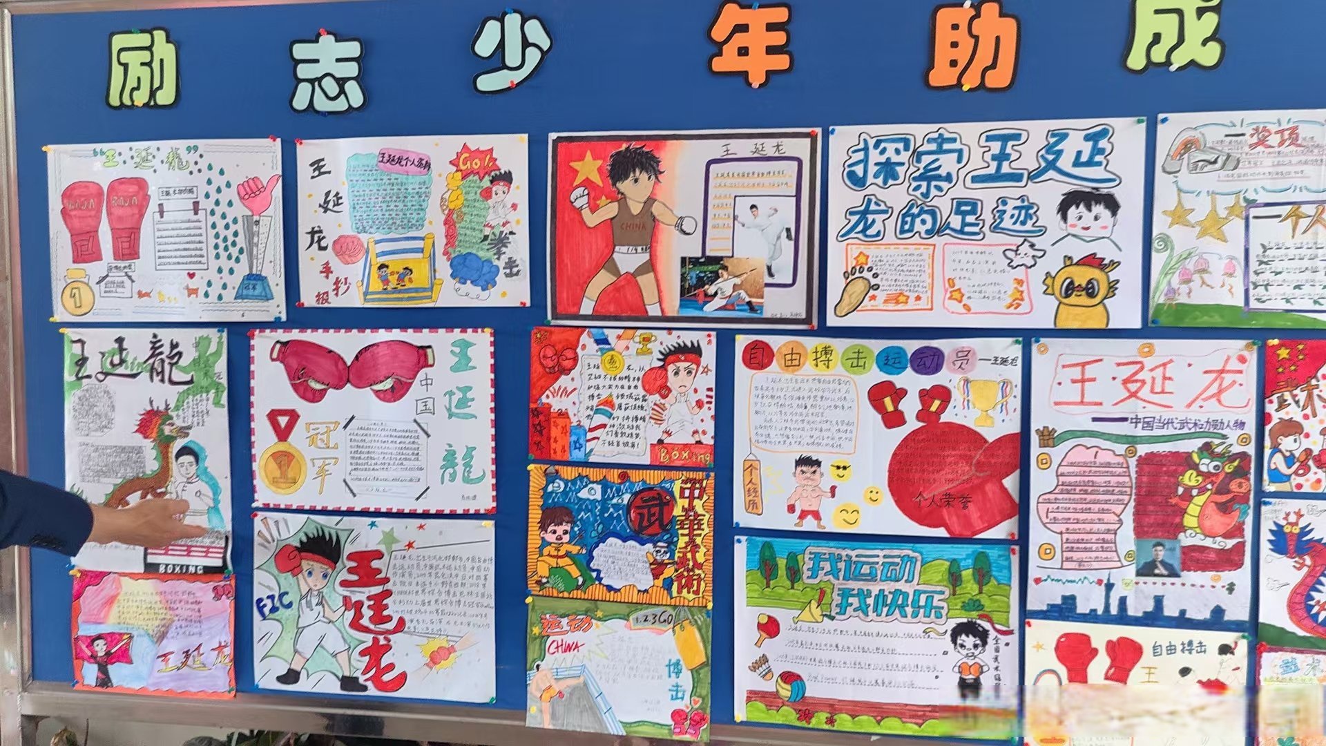 图中展示的是一个以"励志少年 助力成长"为主题的手抄报展览,手抄报上