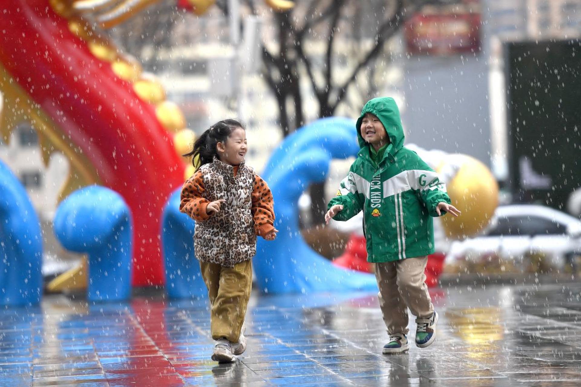 太原太原头条【雨中嬉戏】  3月24日,太原街头,两名孩子在雨中嬉戏.