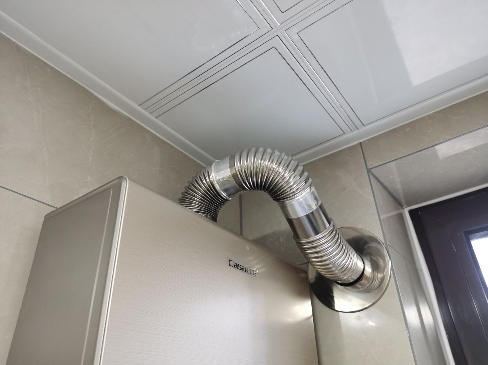 热水器的管子弯弯绕,师傅尽量做到美观 水管太高,排气管太低,弄成这样