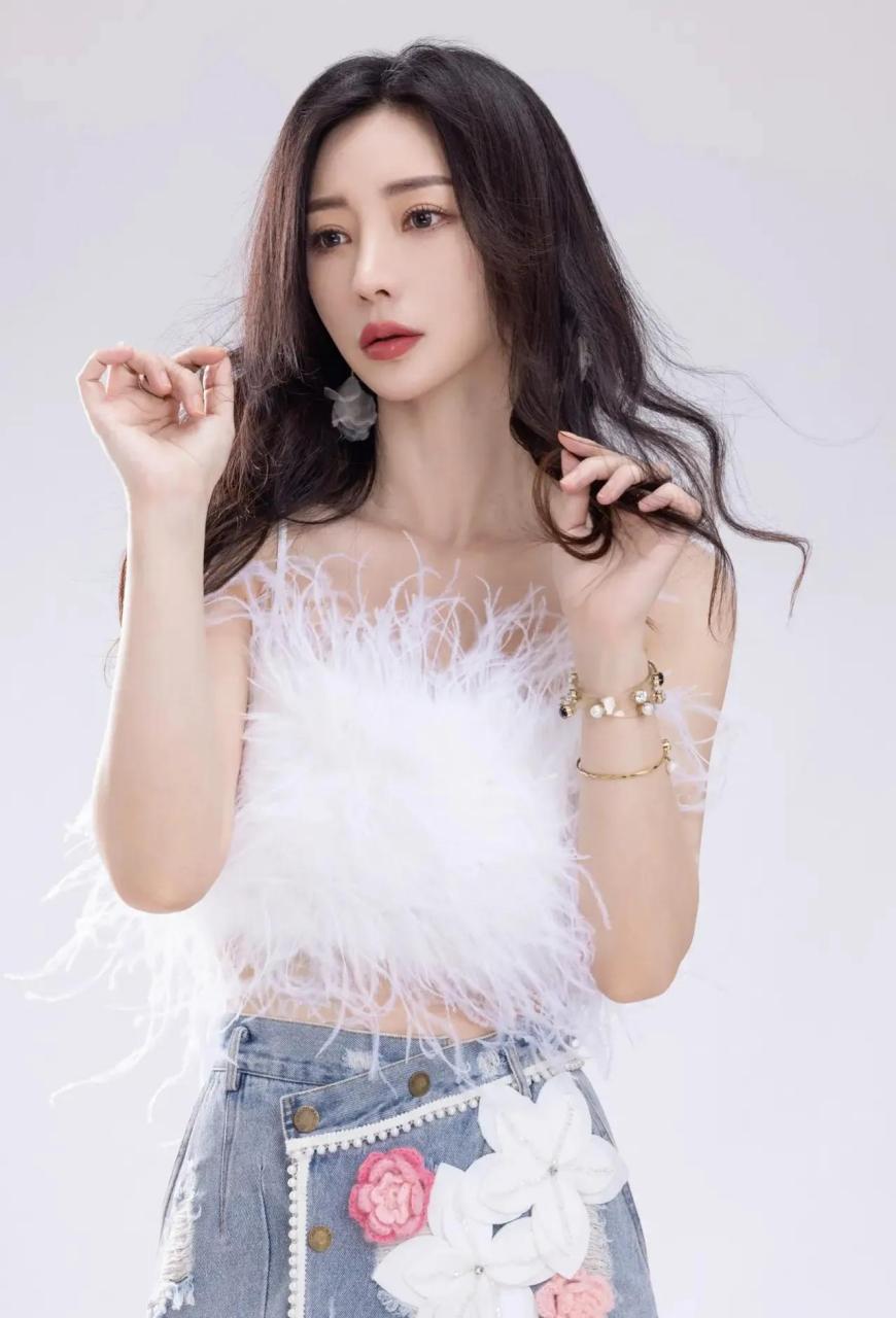在这组时尚大片中,柳岩以纯白色绒毛吊带搭配针织百合花图案牛仔包臀