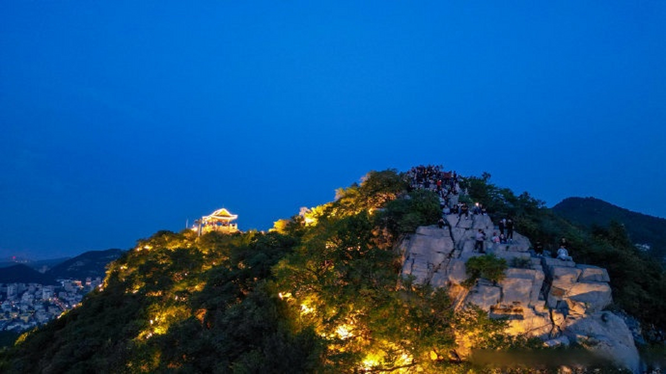 每日傍晚的千佛山山顶,夕阳西下后,数以百计的灯光瞬间点亮,橘色灯光