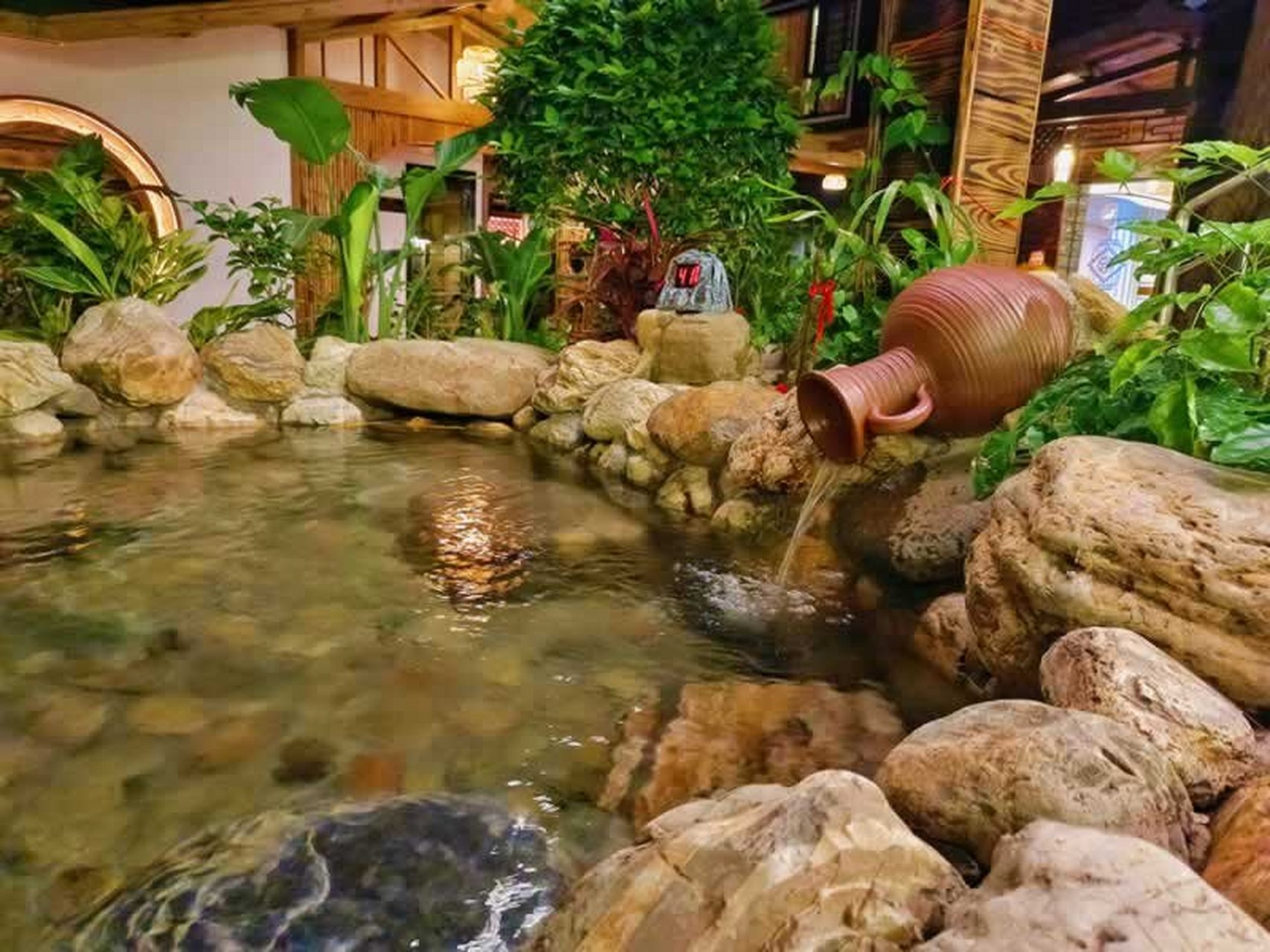 汀溪下土楼温泉民宿欢迎你 室外景观做的非常精致,亭台楼阁,花团锦簇