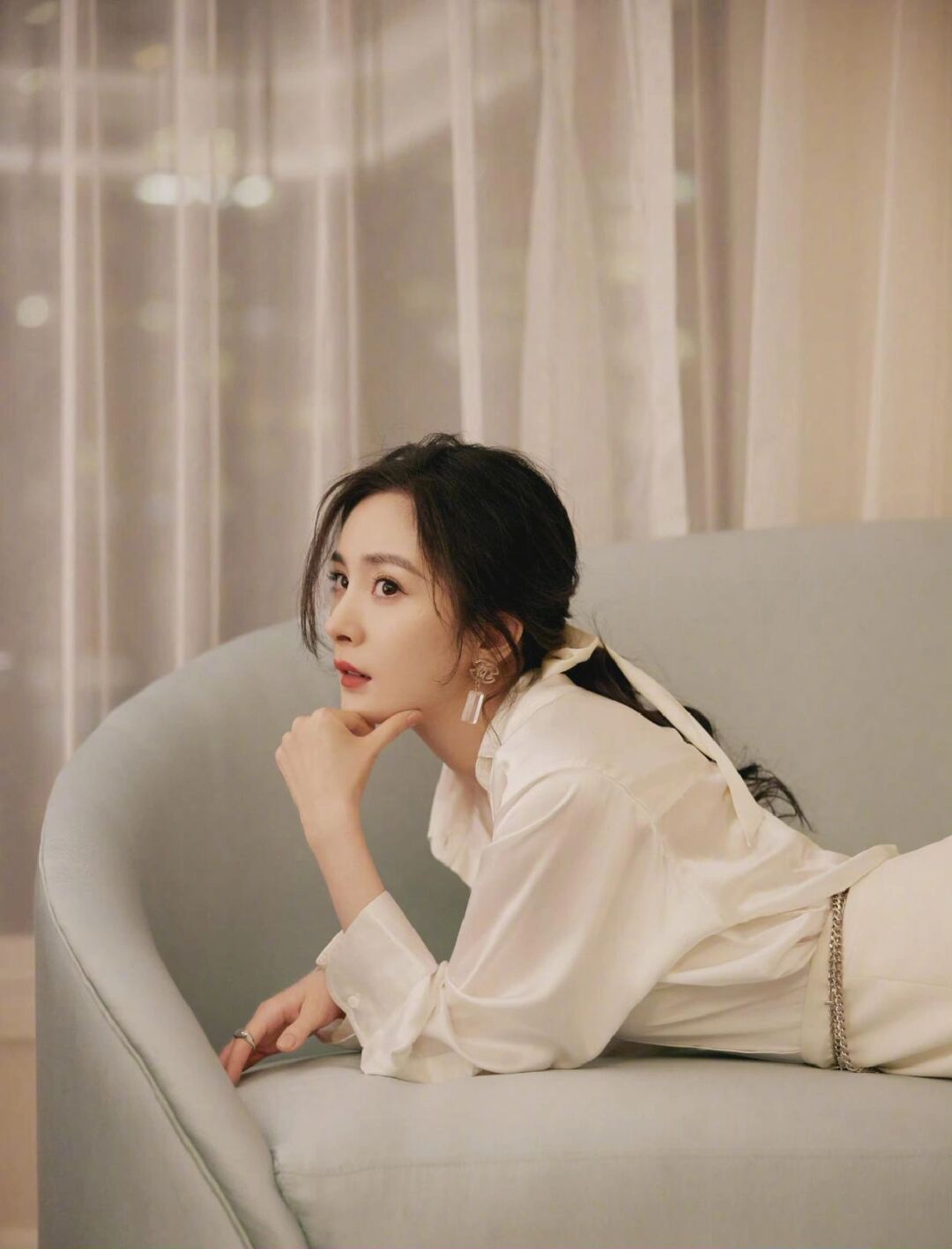杨幂身穿白色绸缎衬衫,搭配同色系高开叉长裙,耳饰和项链点缀,松散低