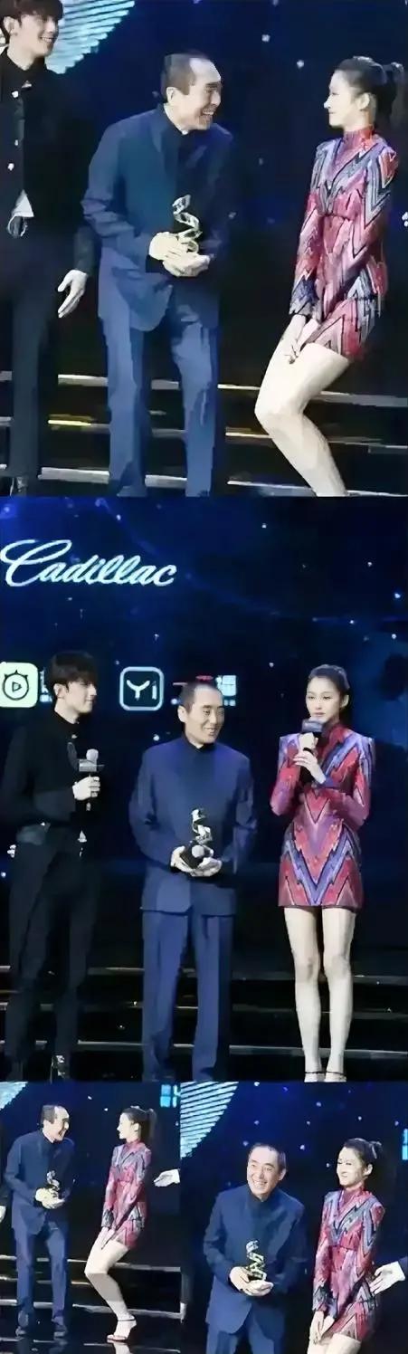 张艺谋看到关晓彤的举动,手上拿着奖杯欣慰地笑了笑.