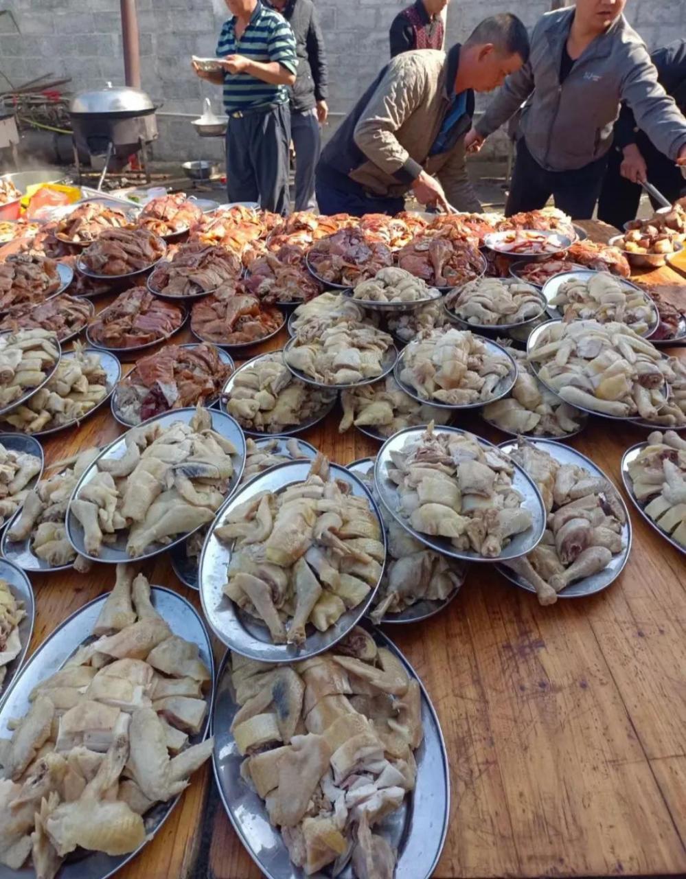 村里办酒席真是热闹,大盆装菜,鸡鸭鱼肉摆满了桌子,请来的大师傅在