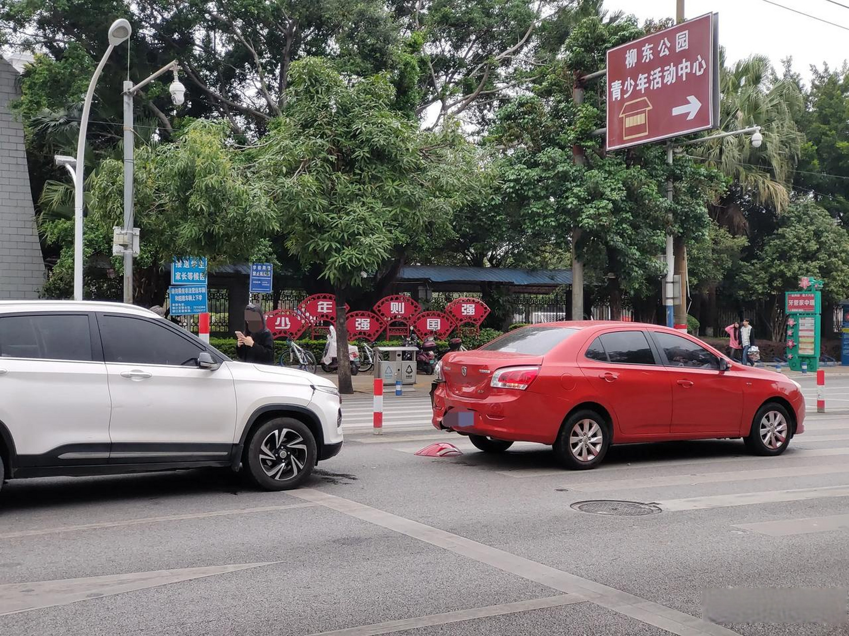 柳州市柳江二中对面马路的人行道上,刚发生一起小汽车追尾事故.