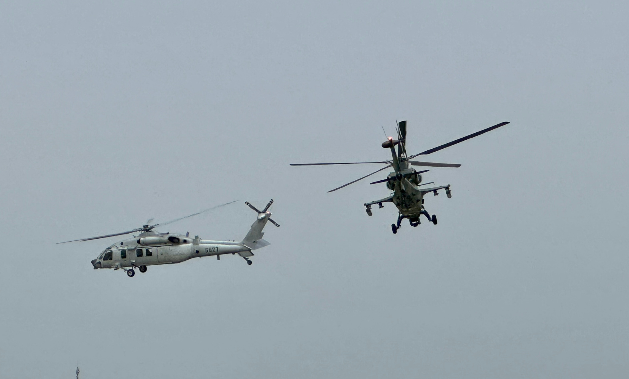 美军101空中突击师搭乘uh-60黑鹰直升机,在ah-64阿帕奇武装直升机的