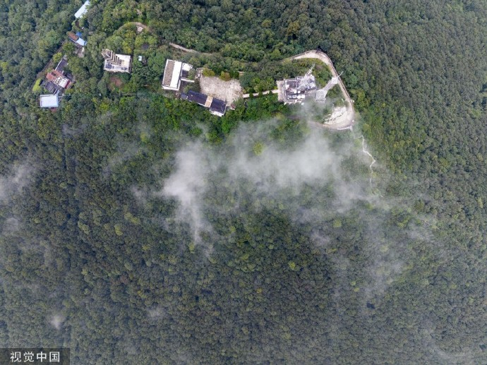 湖北省襄阳市,虎头山雨后云雾缭绕,雾气盘旋在山巅的电视塔建筑周边