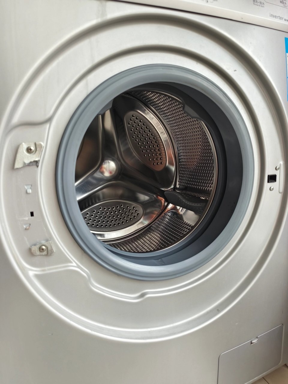 今天闺女去阳台上玩儿,一屁股把滚筒洗衣机的门儿坐掉了.