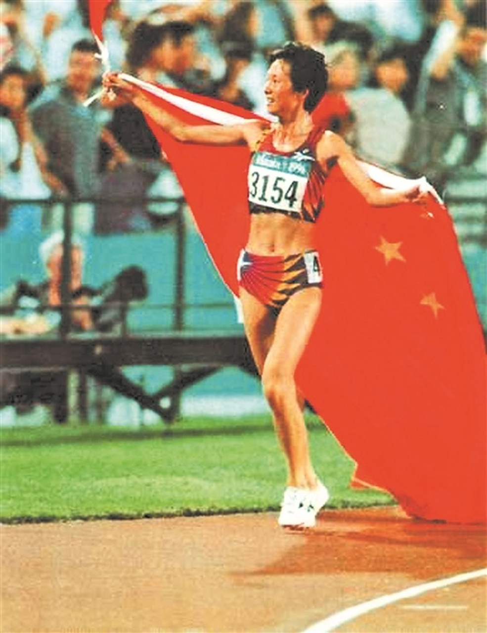 身披国旗跑步,中国运动员王军霞冲过终点之后,她接过留学生扔到她手上
