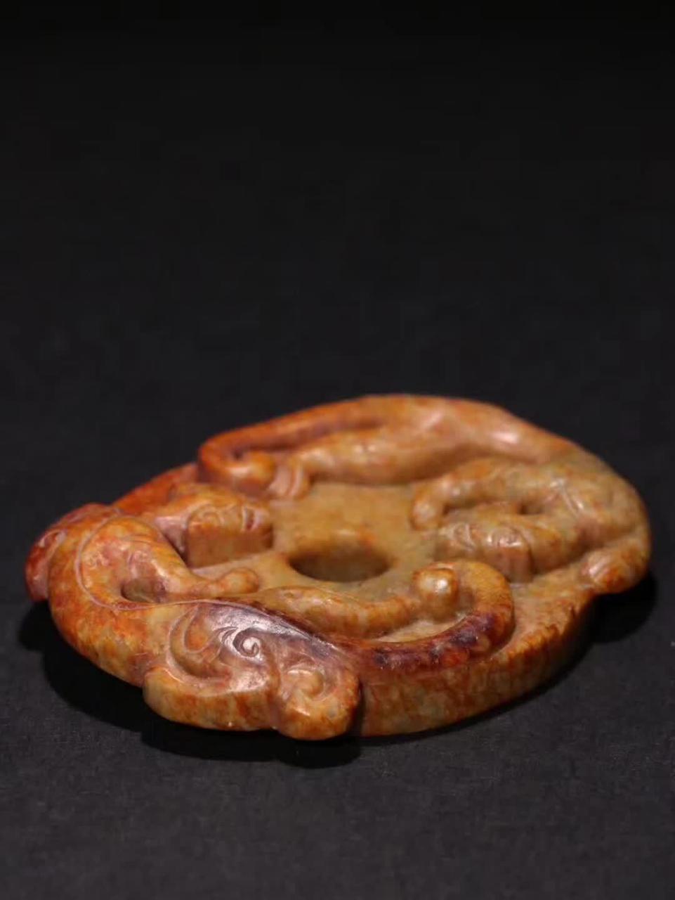自明代的和田黄玉《双螭龙》玉璧,规格精巧,宽度为6.6cm,高度为5.