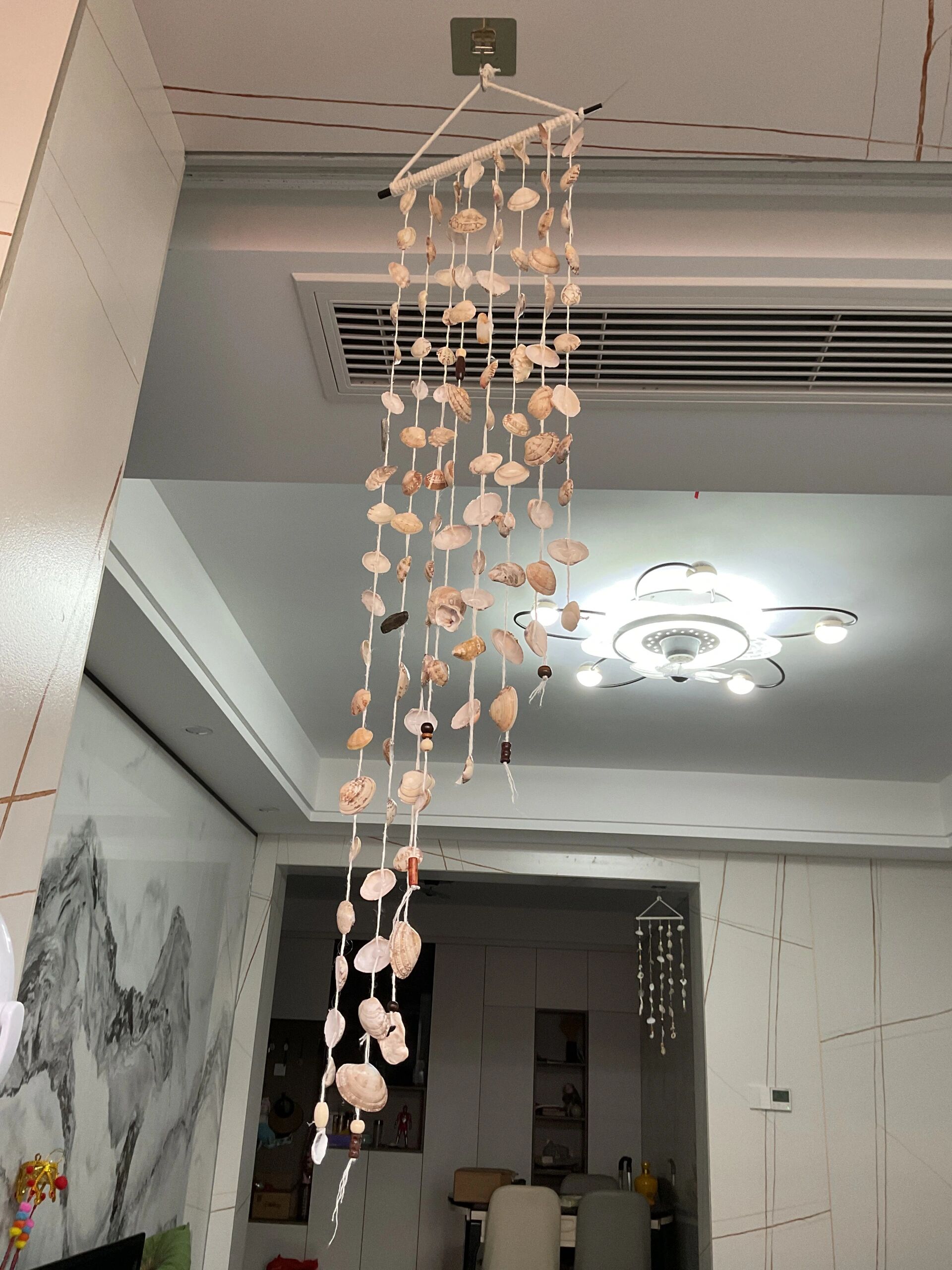 贝壳风铃diy90 第一步:用筷子做骨架 缠上棉线 第二步:用打孔器给