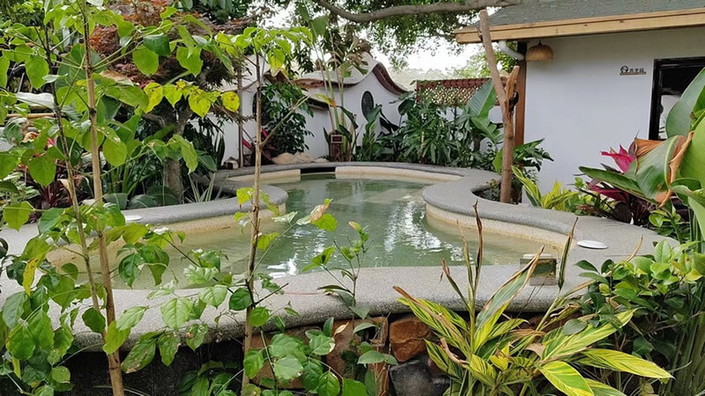 汀溪下土楼温泉民宿欢迎你 室外景观做的非常精致,亭台楼阁,花团锦簇