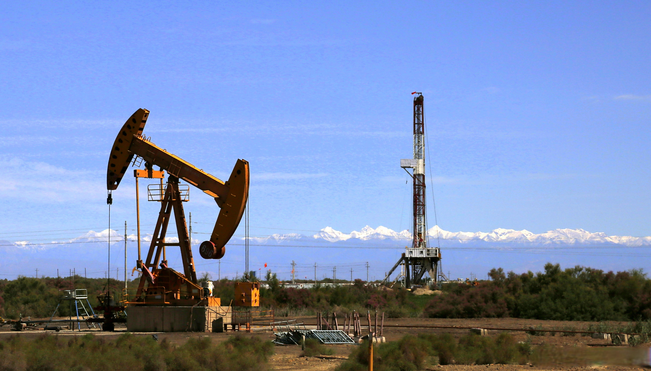 西北油田的美 是新鲜的空气,蔚蓝的天空 巍峨的井架,欢快的抽油机 是