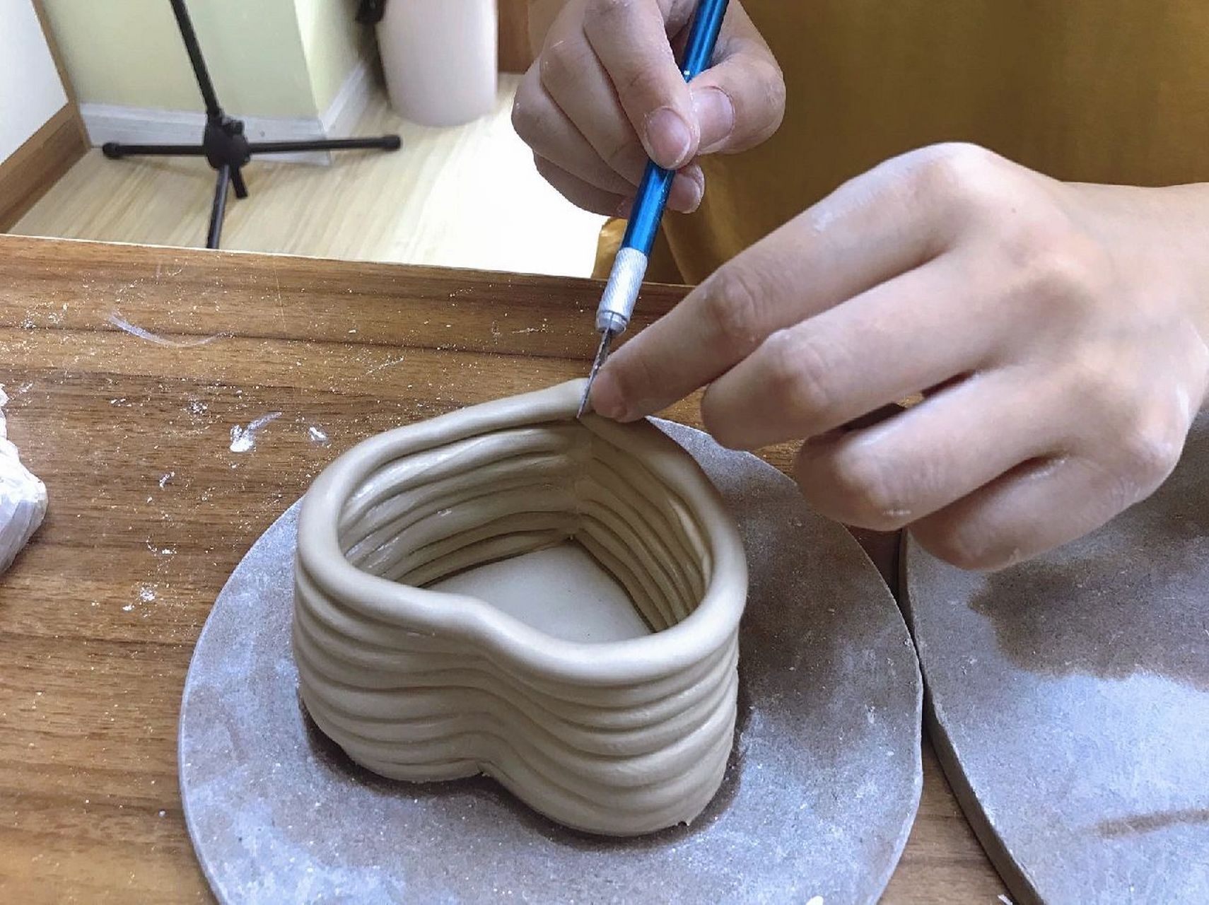 这是一节以泥条盘筑法成型的陶艺课程,首先要用泥板切出一个爱心型的