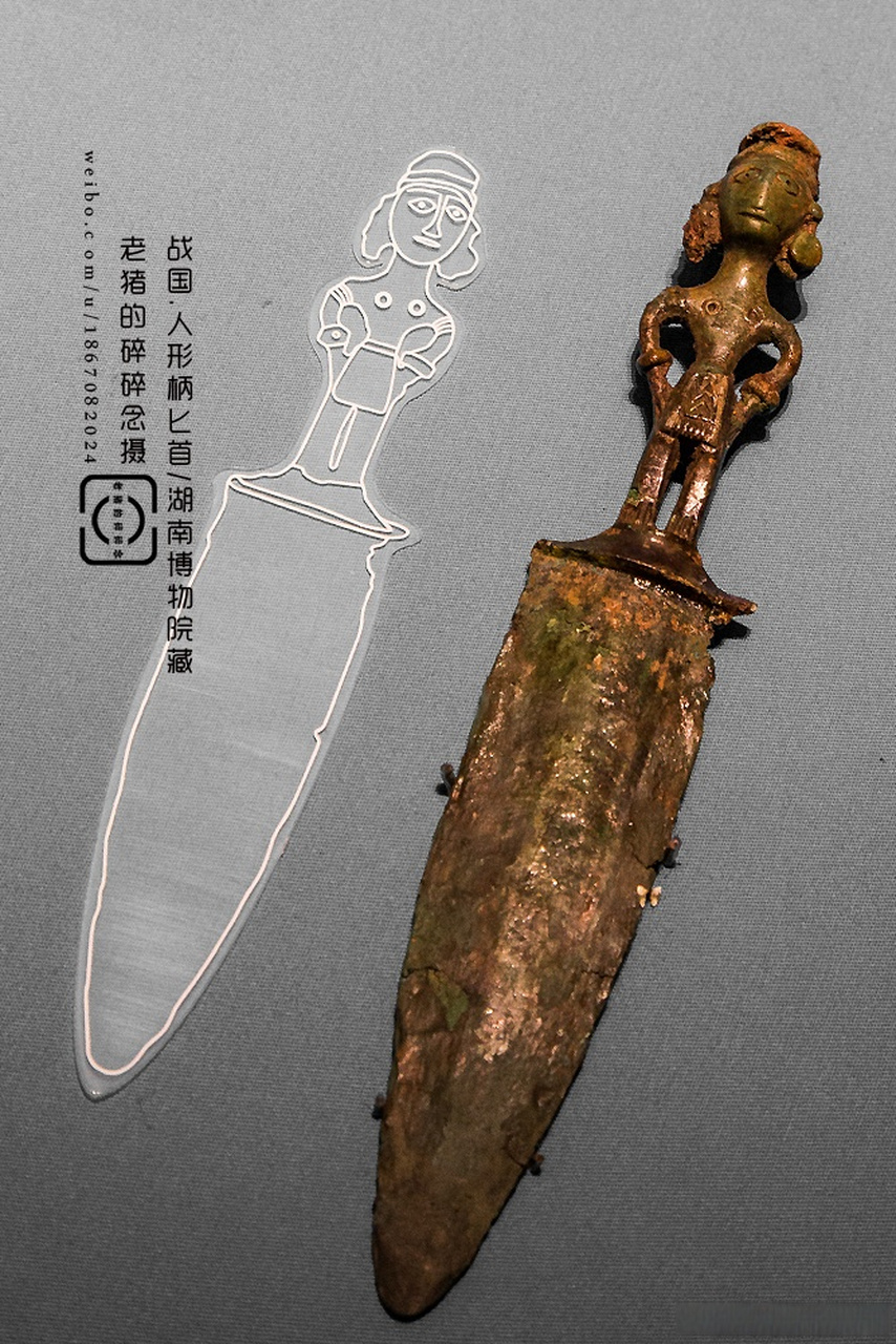 站在刀柄的这位圆眼高鼻梁,挽圆饼发髻,长辫垂及