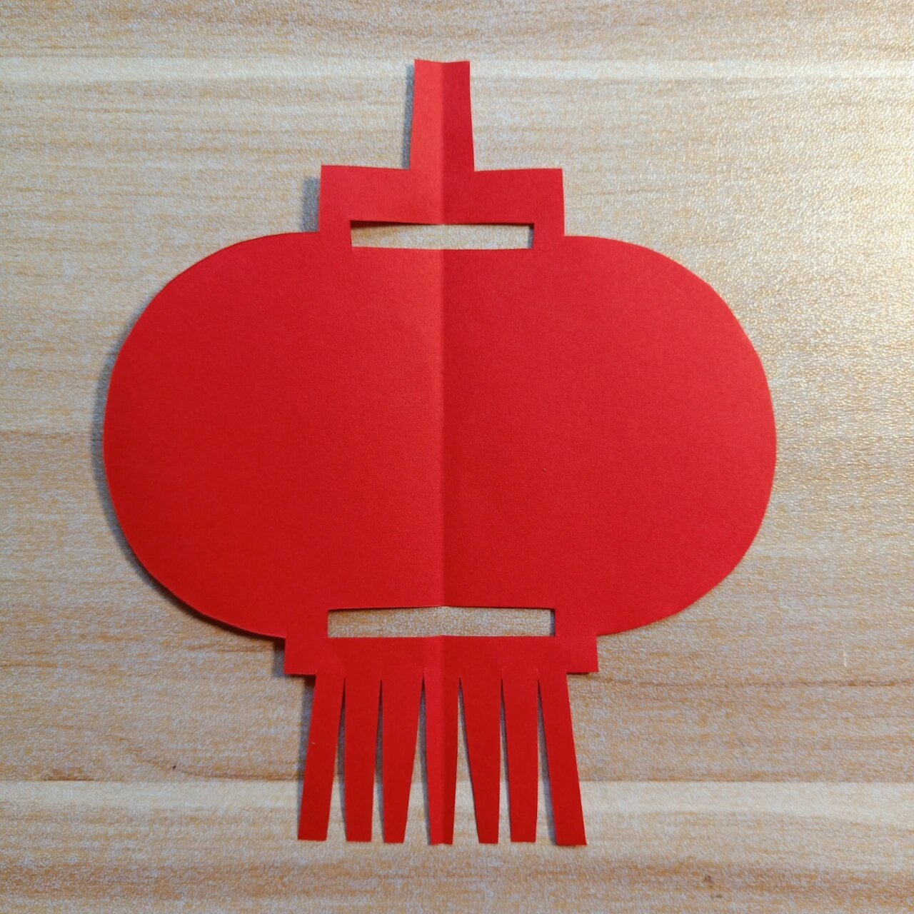 美术:剪纸～单独纹样～灯笼～ 取一张红纸,对折,画好一半的图案,小心