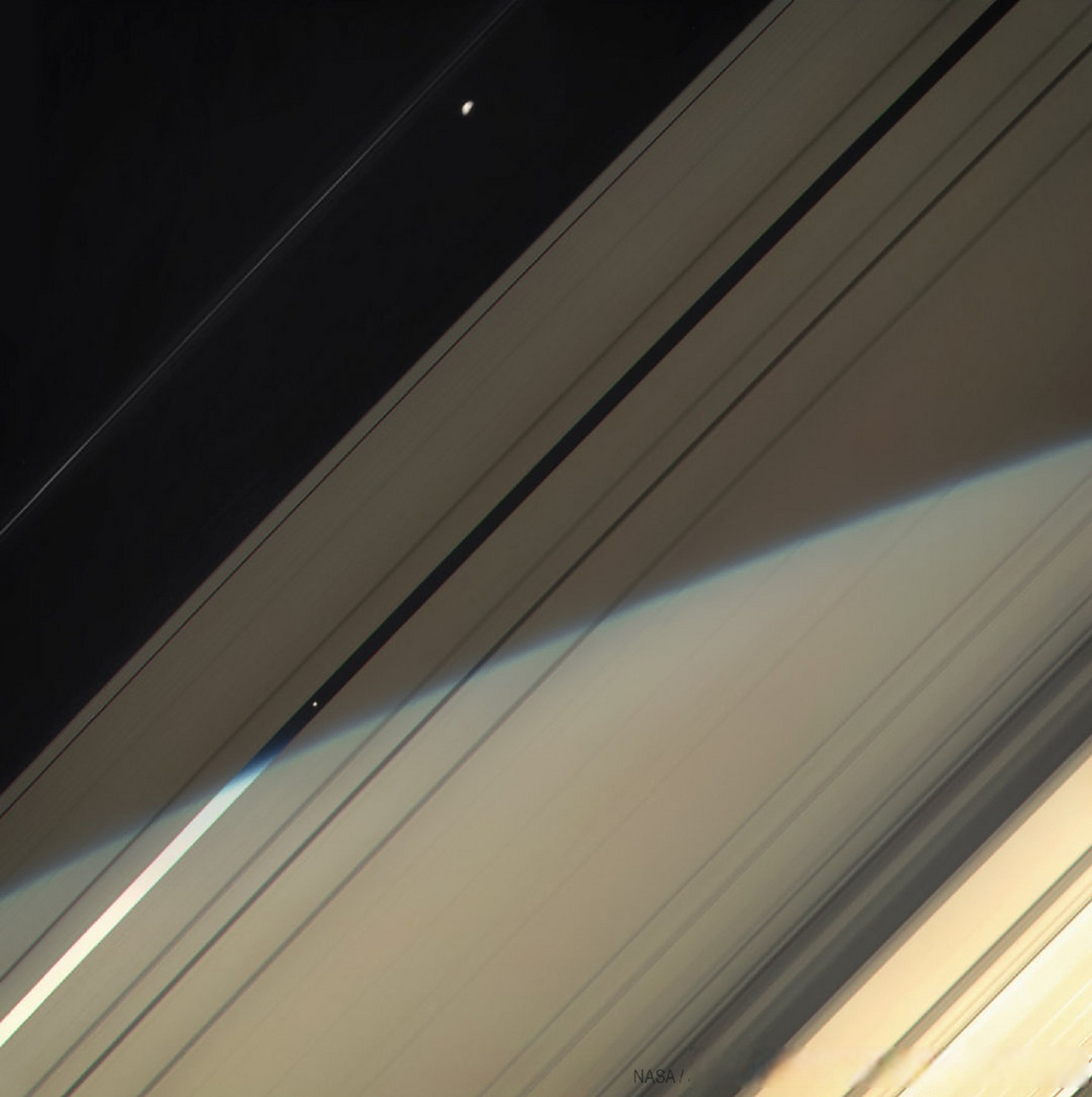 土星的卫星普罗米修斯(土卫十六,上)和潘(土卫十一,中心左下)