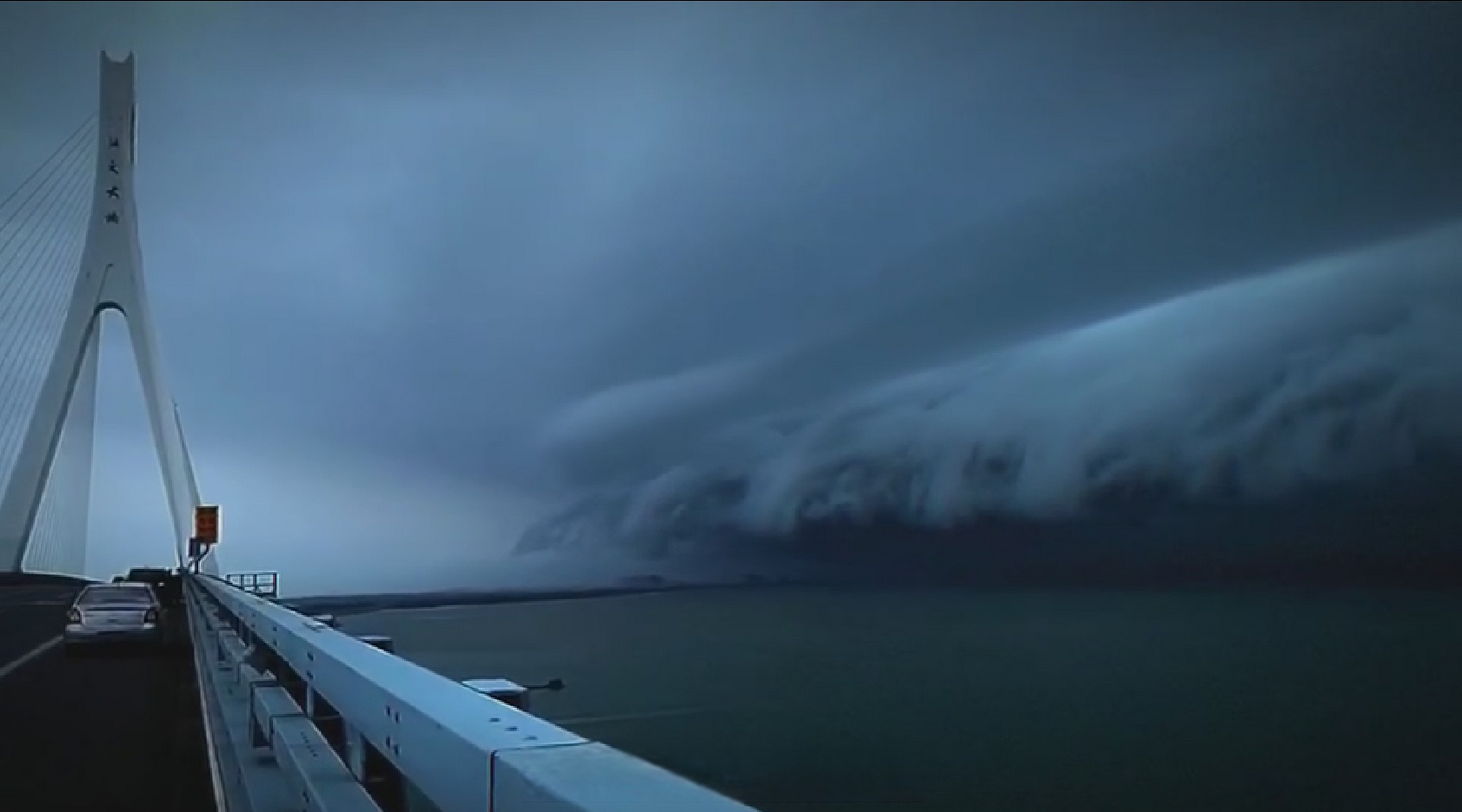 今天下午,海南海文大桥附近,黑压压的弧状积雨云逼近