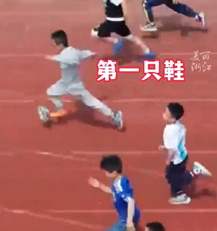 浙江杭州,小学运动会100米比赛现场,一名小男孩先后跑掉两只鞋,赤脚