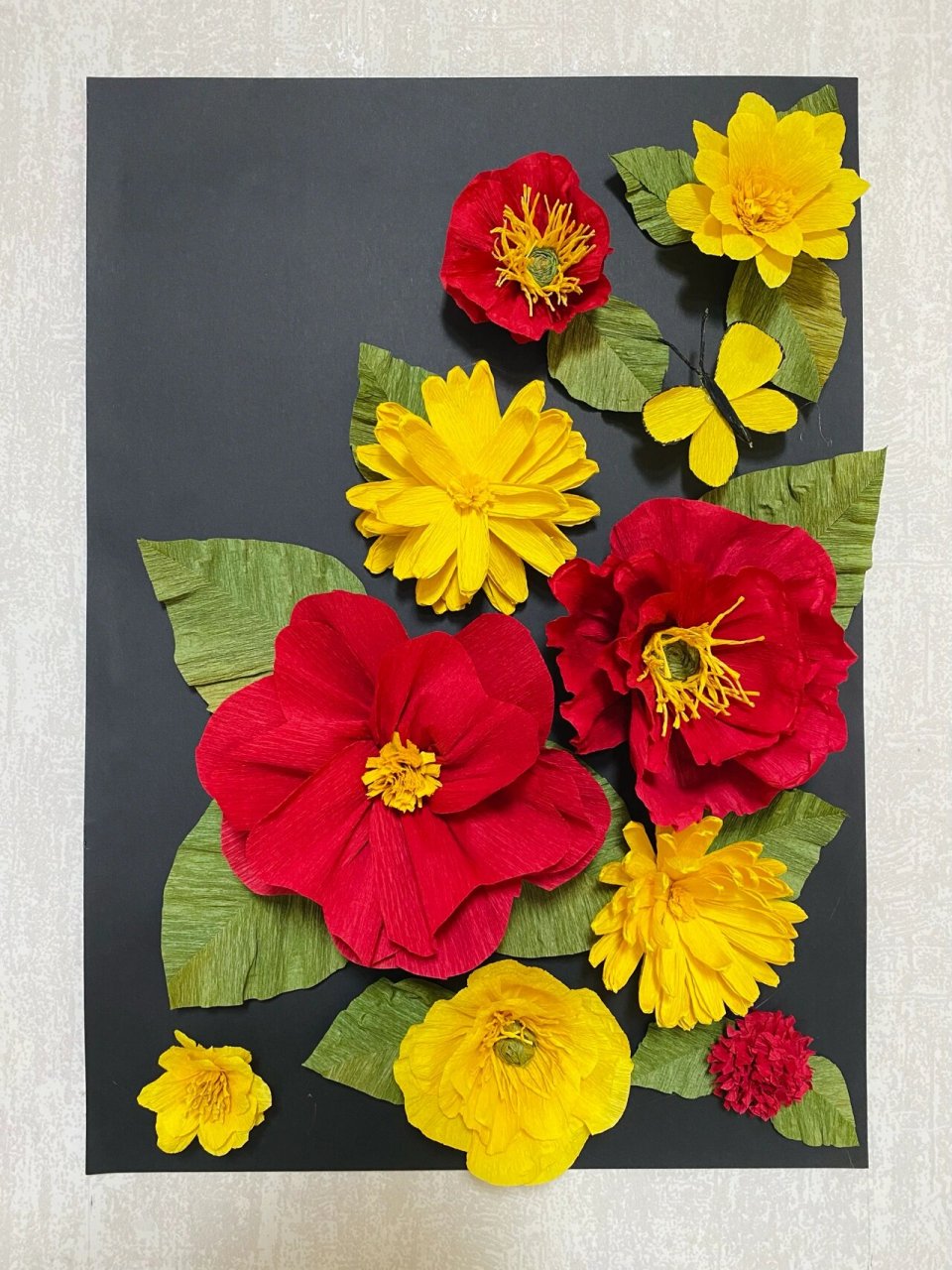 ①皱纹纸做好想要的花蕊和花瓣形状 ②将剪好的花瓣围绕花蕊交错粘贴