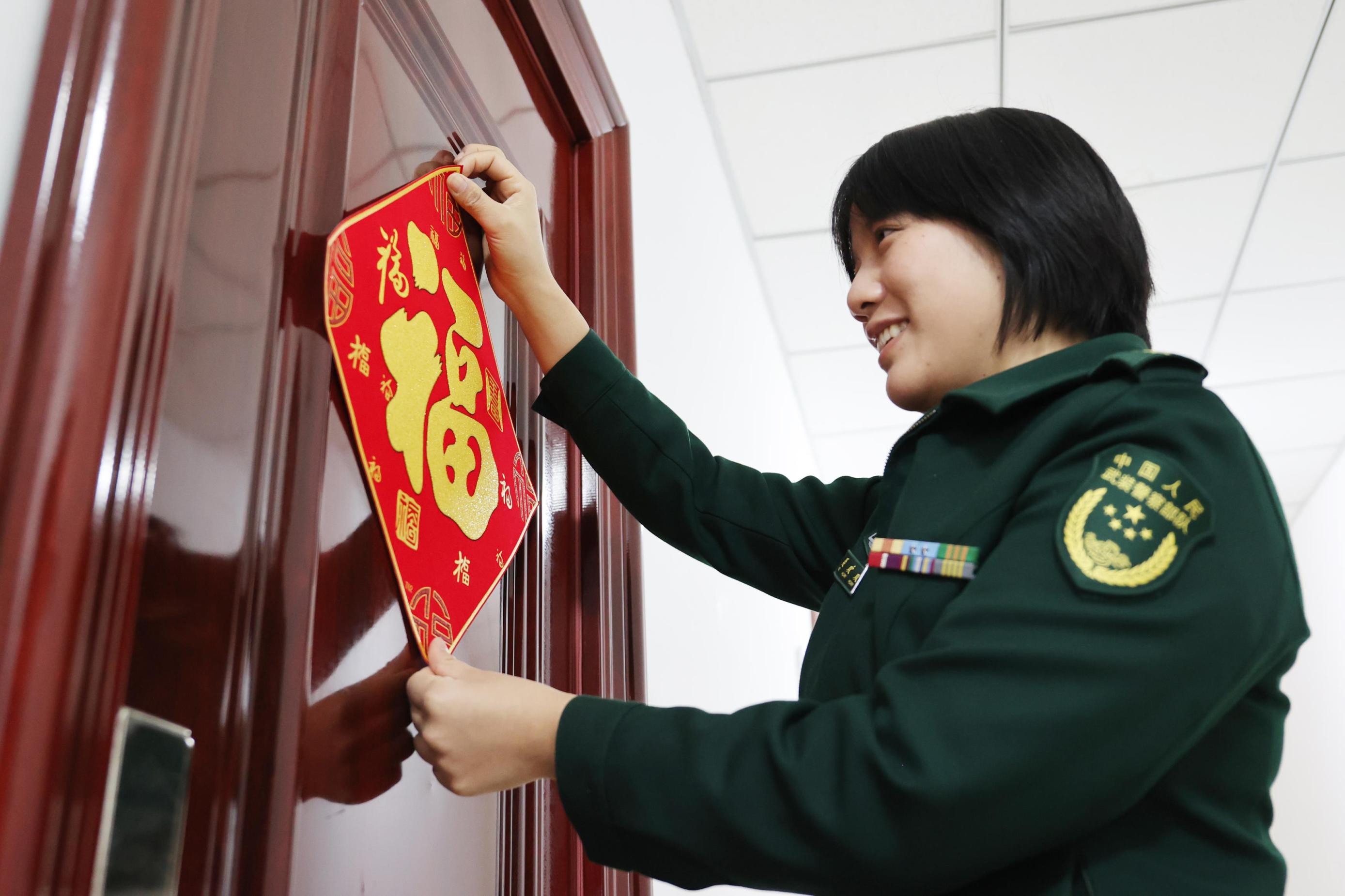 官兵们忙得不亦乐乎,挂灯笼,贴春联,营区里被装点得红红火火,年味十足