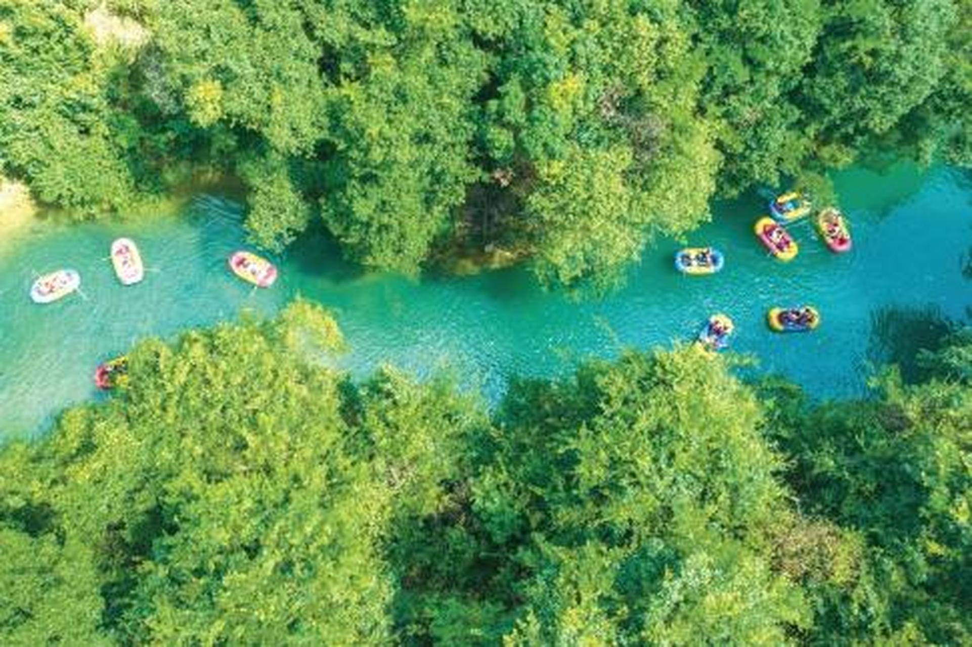 8月15日,游客在贵州省荔波小七孔风景区体验漂流项目.