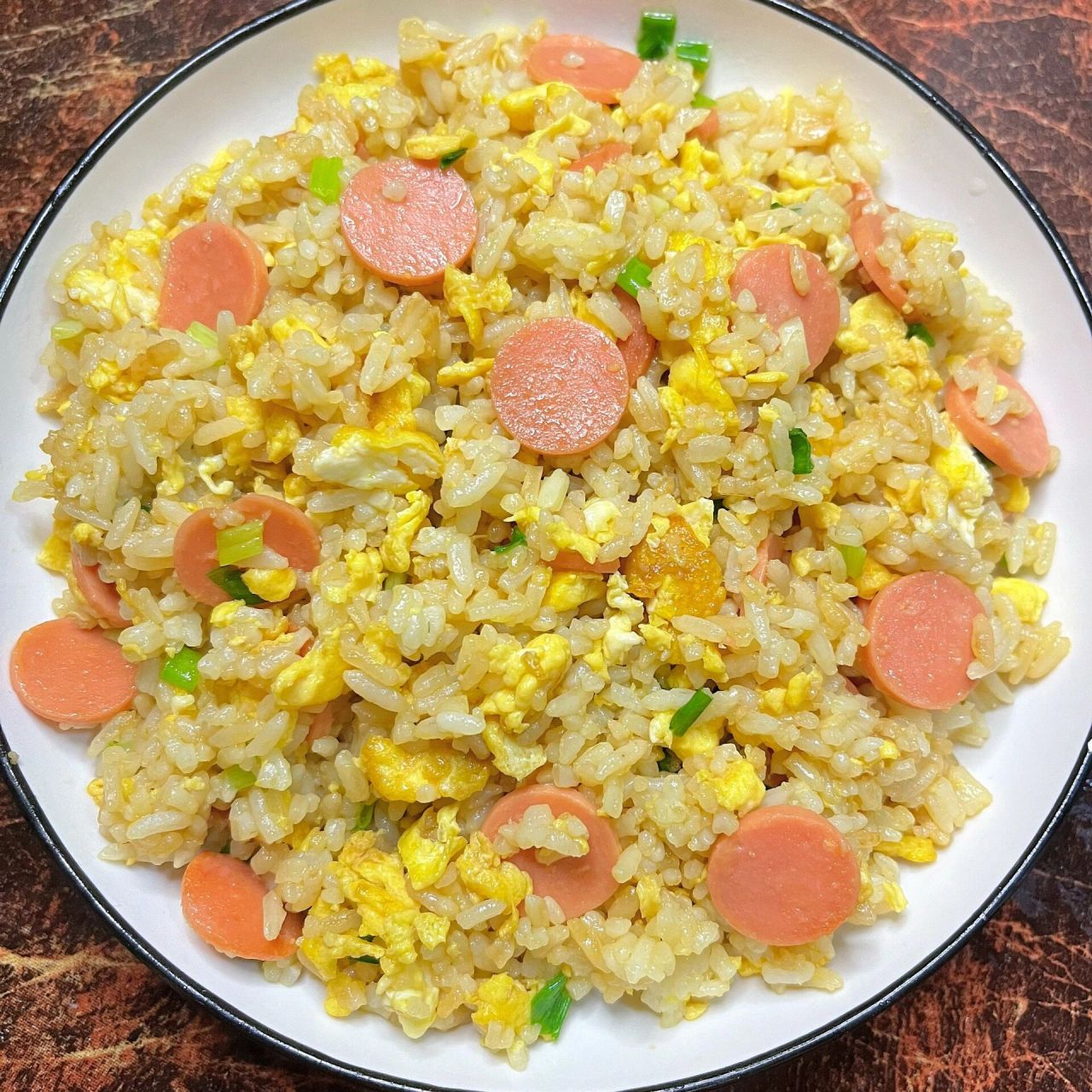 食材:隔夜饭,火腿肠,鸡蛋,葱花,生抽,盐 看着都好吃的蛋炒饭做法也很