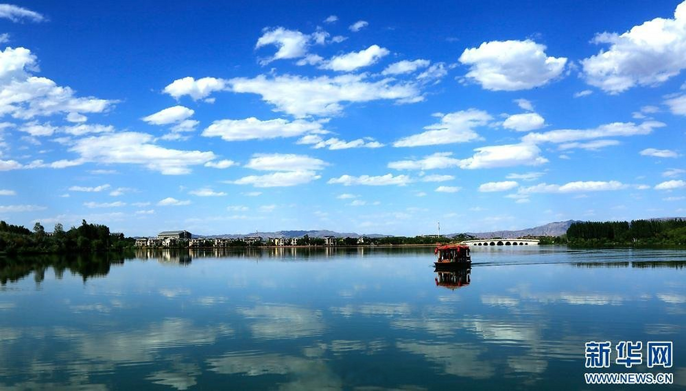 7月16日,在甘肃省张掖市甘州区芦水湾生态旅游度假区,游客乘画舫在