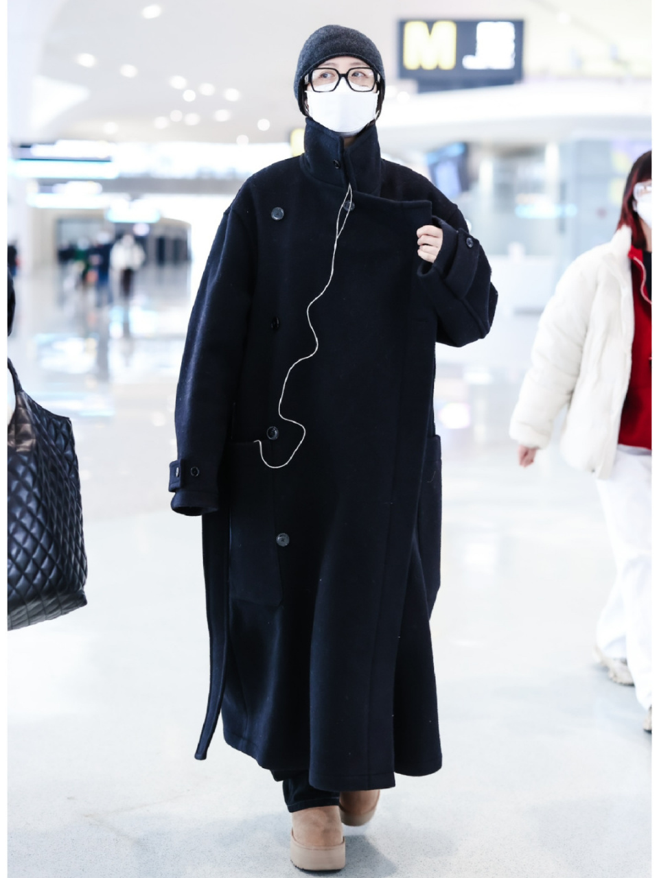 周雨彤221226机场私服,黑色长大衣搭配灰色冷帽与针织围巾,随性休闲的