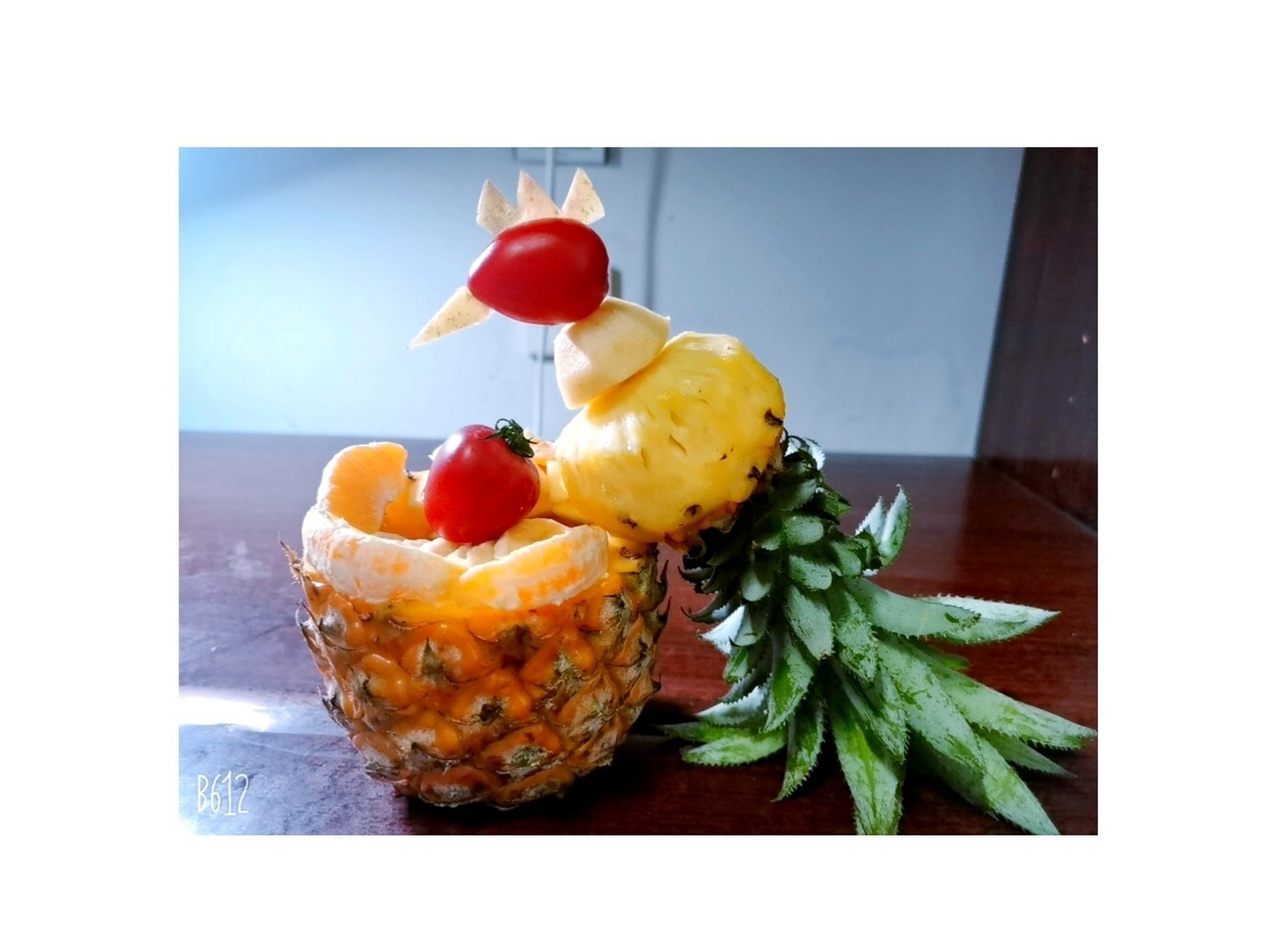 创意水果拼盘——菠萝凤凰! 1.将菠萝切成两半,上面一半切小一点. 2.