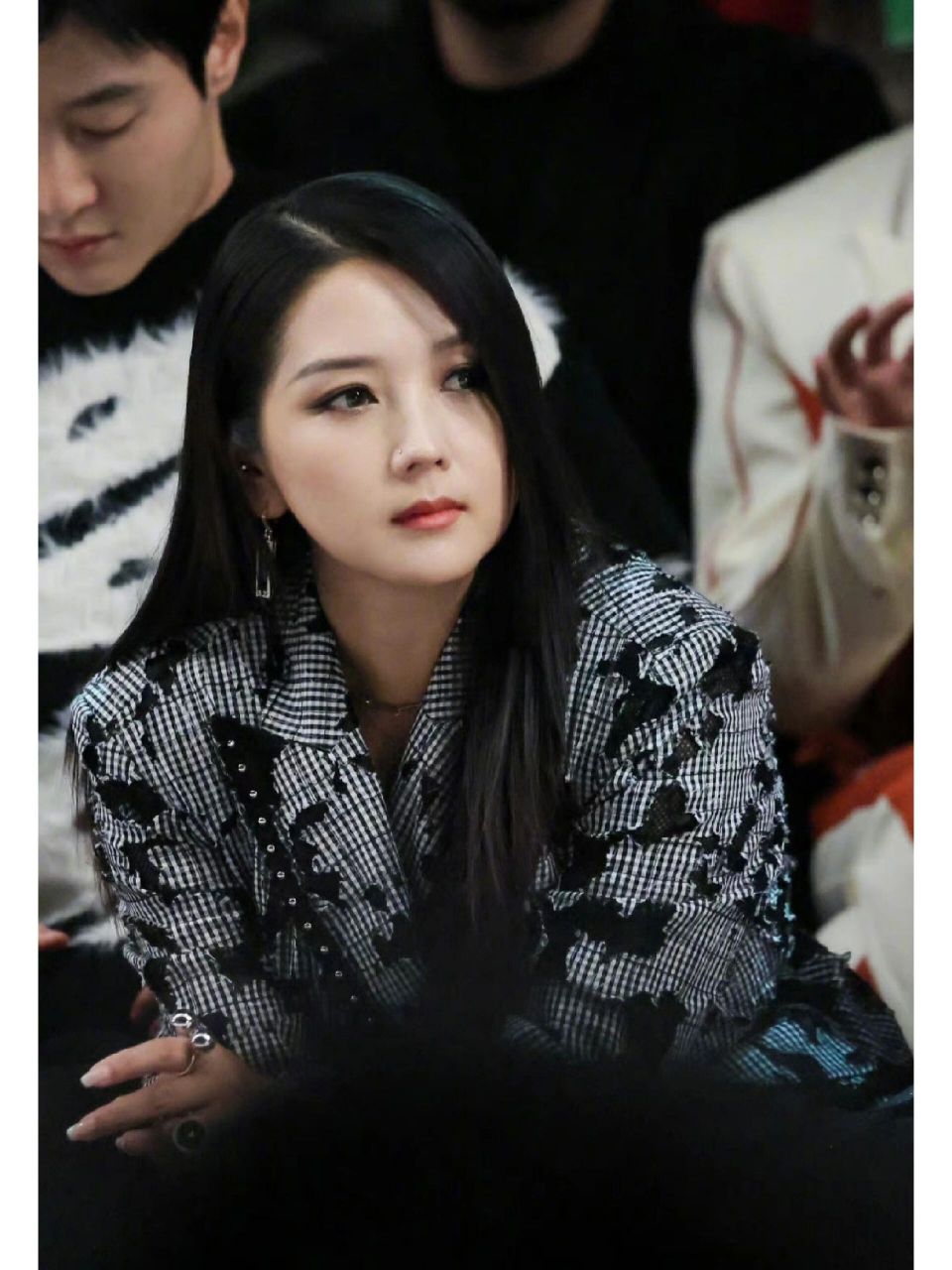 照片中,何洁秀发披肩,上身一件宽松西装,绑一条花腰带,下身短裤,搭配