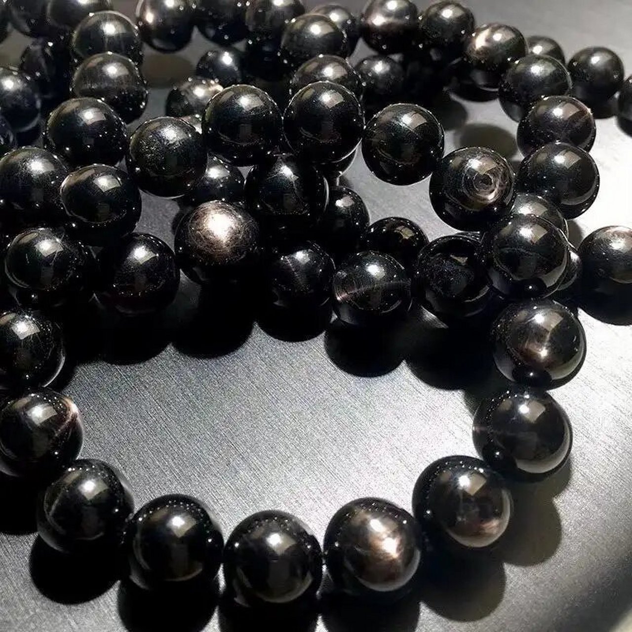 96金运石名紫苏辉石(hvpersthene),也叫黑银线石,是一种常见的成岩